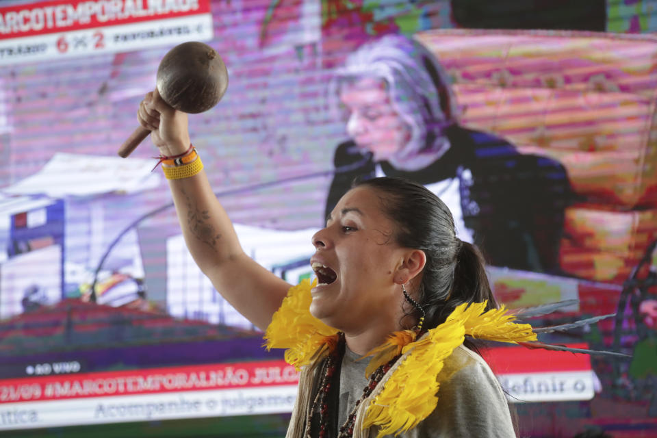 An Indigenous woman celebrates a Supreme Court ruling to enshrine Indigenous land rights, in Brasilia, Brazil, Thursday, Sept. 21, 2023. Six of the 11 Supreme Court justices voted against establishing a cut-off date after which Indigenous peoples could not claim new territory. (AP Photo/Gustavo Moreno)