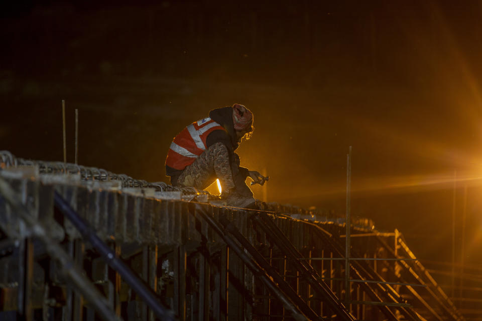 Workers employed by the Megha Engineering And Infrastructures Limited (MEIL) work on the construction of a bridge which will connect Sonamarg to Nilgrar Tunnel in Baltal area, northeast of Srinagar, Indian controlled Kashmir, Tuesday, Sept. 28, 2021. High in a rocky Himalayan mountain range, hundreds of people are working on an ambitious project to drill tunnels and construct bridges to connect the Kashmir Valley with Ladakh, a cold-desert region isolated half the year because of massive snowfall. The $932 million project’s last tunnel, about 14 kilometers (9 miles) long, will bypass the challenging Zojila pass and connect Sonamarg with Ladakh. Officials say it will be India’s longest and highest tunnel at 11,500 feet (3,485 meters). (AP Photo/Dar Yasin)