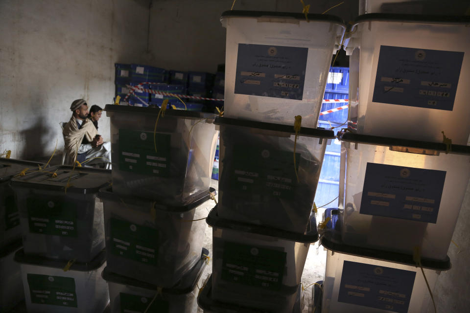 Afghan workers of the election commission office sit as ballot boxes are piled after votes in Jalalabad, east of Kabul, Afghanistan, Sunday, April 6, 2014. Across Afghanistan, voters turned out in droves Saturday to cast ballots in a crucial presidential election. The vote will decide who will replace President Hamid Karzai, who is barred constitutionally from seeking a third term. Partial results are expected as soon as Sunday. (AP photo/Rahmat Gul)