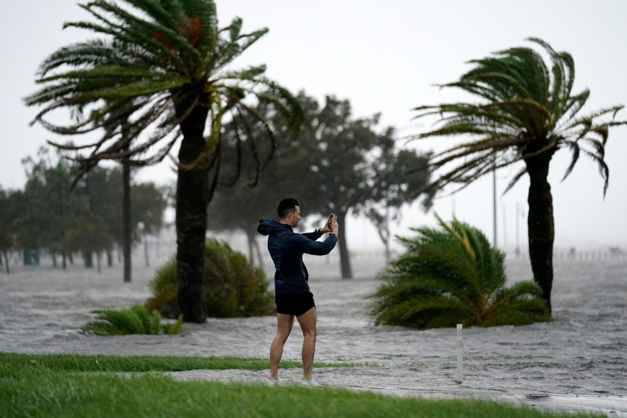 A man takes photos on the edge of Lake Pontchartrain ahead of approaching Hurricane Ida in New Orleans on Sunday, Aug. 29, 2021.