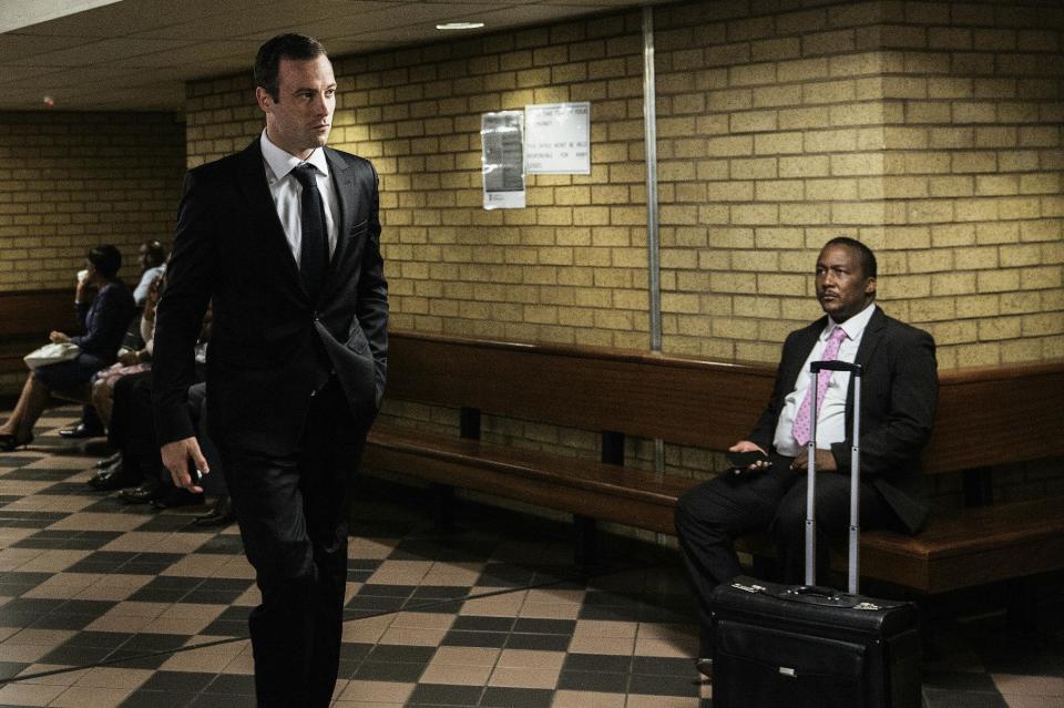 El excampeón paralímpico sudafricano Oscar Pistorius (izq) llegando al Tribunal Supremo de Pretoria para una audiencia por el asesinato de su novia hace tres años, el 18 de abril de 2016 en Pretoria, Sudáfrica (AFP/Archivos | Gianluigi Guercia)
