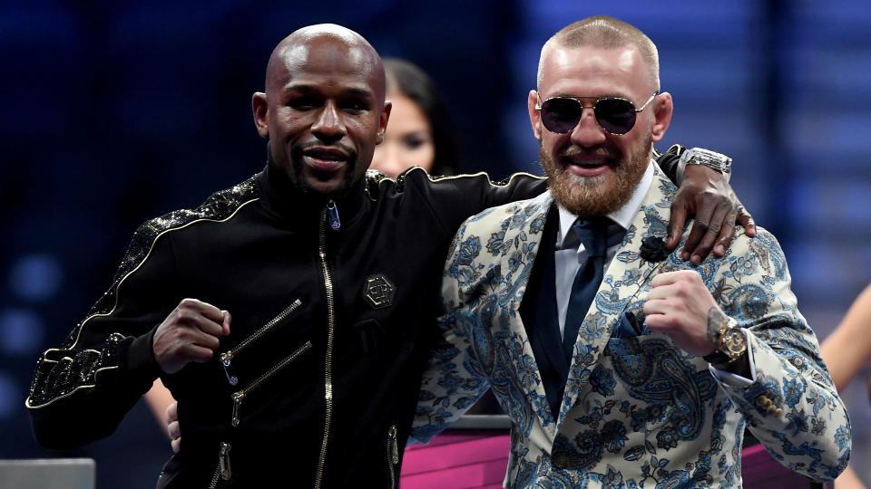 Floyd Mayweather Jr. and Conor McGregor were happy to pose with each other after their big payday. (Getty)