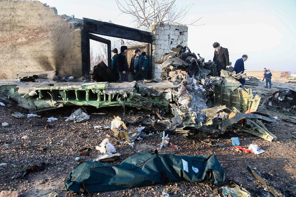 People stand near the wreckage after a Ukrainian plane carrying 176 passengers crashed near Imam Khomeini airport in Tehran on January 8, 2020. (Photo by Rouhollah Vahdati/ISNA/AFP via Getty Images)