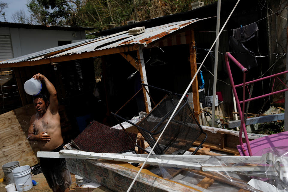 A man&nbsp;showers with water from a well on a Canovanas street on Sept. 26. (Photo: Carlos Garcia Rawlins/Reuters)