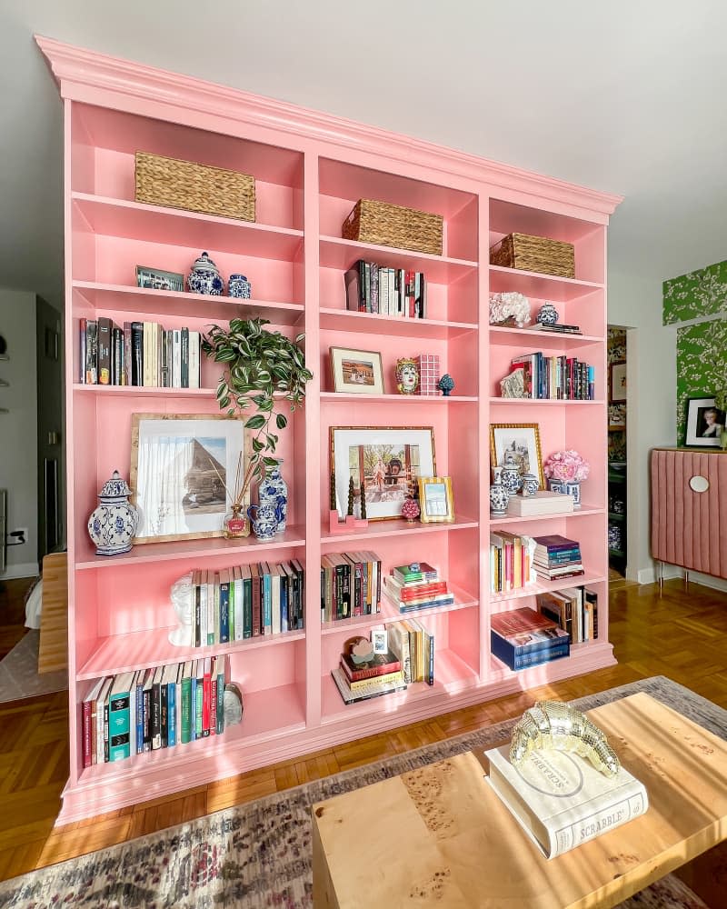 Pink bookshelf in colorful living room.