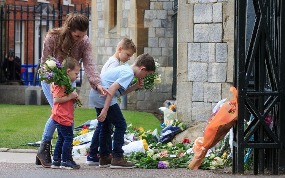  Rachael Hertzke and her sons Liam 10, Finn 7 and Jack 3 from Virginia Water, lay flowers at the gate -  Jamie Lorriman