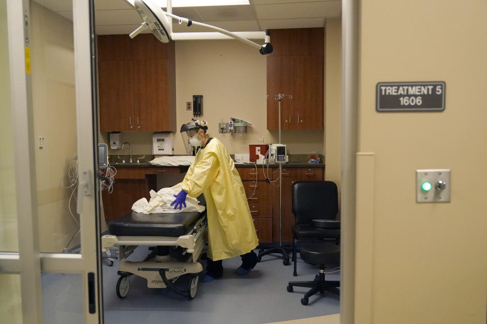 FILE - In this Nov. 24, 2020, file photo, registered nurse Chrissie Burkhiser cleans an emergency room suite after treating a COVID-19 patient at Scotland County Hospital in Memphis, Mo. The U.S. has seen a dramatic turnaround since December and January, when hospitals were teeming with patients after holiday gatherings and pandemic fatigue caused a surge in cases and deaths. (AP Photo/Jeff Roberson, File)