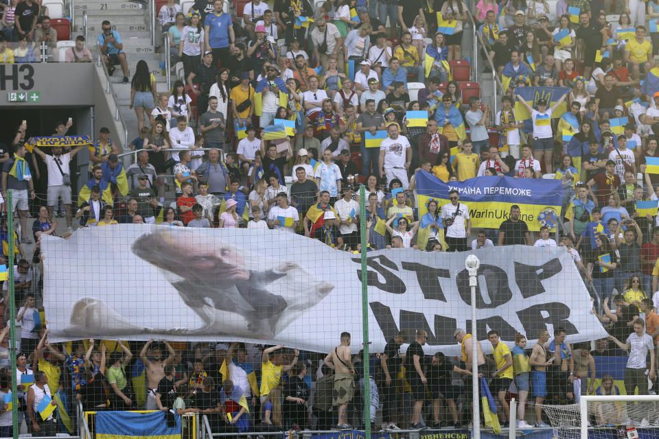 FILE - Ukraine supporters unfurl a "Stop War" banner on the stands during the UEFA Nations League soccer match between Ukraine and Armenia, in Lodz, Poland, on June 11, 2022. One year after the invasion of Ukraine began, Russia's reintegration into the world of sports threatens to create the biggest rift in the Olympic movement since the Cold War. (AP Photo/Michal Dyjuk)