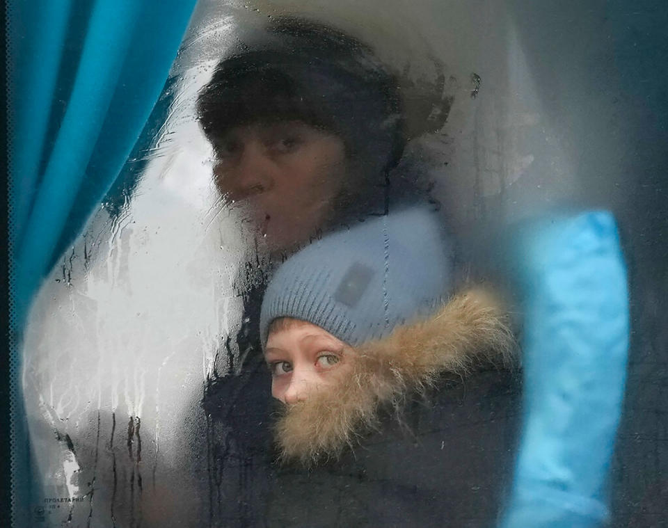 A woman and child peer out of the window of a bus as they leave Sievierodonetsk, Luhansk region, Ukraine, on Feb. 24.<span class="copyright">Vadim Ghirda—AP</span>