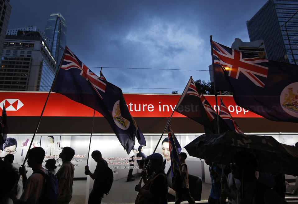 In this July 1, 2013, file photo, protesters raise Hong Kong colonial flags during a march in a downtown street at an annual pro-democracy protest in Hong Kong. A national security law enacted in 2020 and COVID-19 restrictions have stifled major protests in Hong Kong including an annual march on July 1. (AP Photo/Vincent Yu, File)