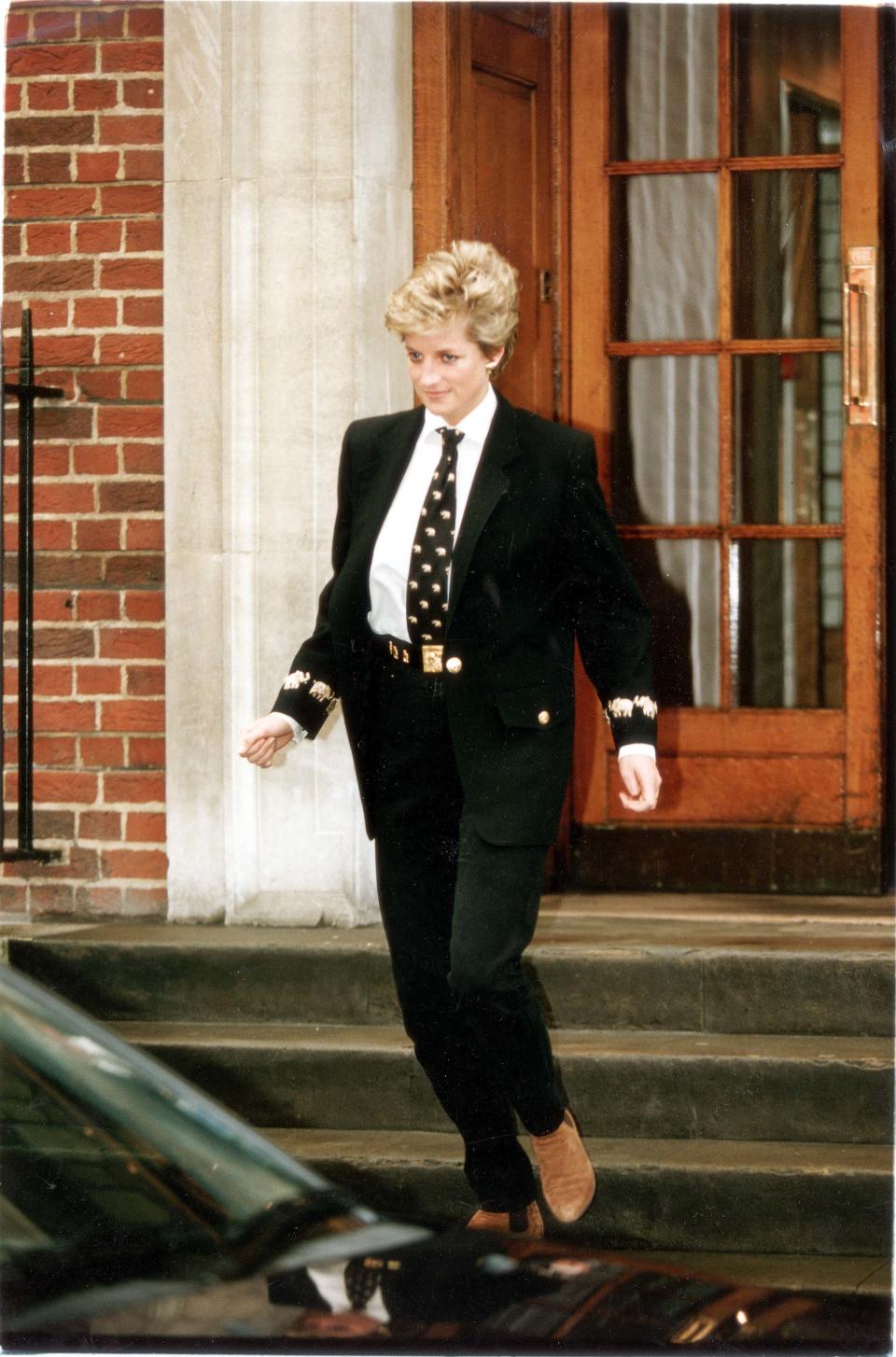 Diana became more experimental with her fashion looks in the 1990s, as this androgynous ensemble illustrates. This black suit comprised an oversized blazer with elephant embellishments on the sleeve. Diana wore also chose a gold statement belt with a large buckle and a tie with elephants on it, to match the sleeves. (Mike Forster/Daily Mail/Shutterstock)