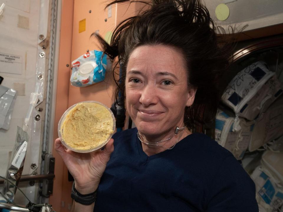 astronaut megan mcarthur holds up a hummus container on the space station