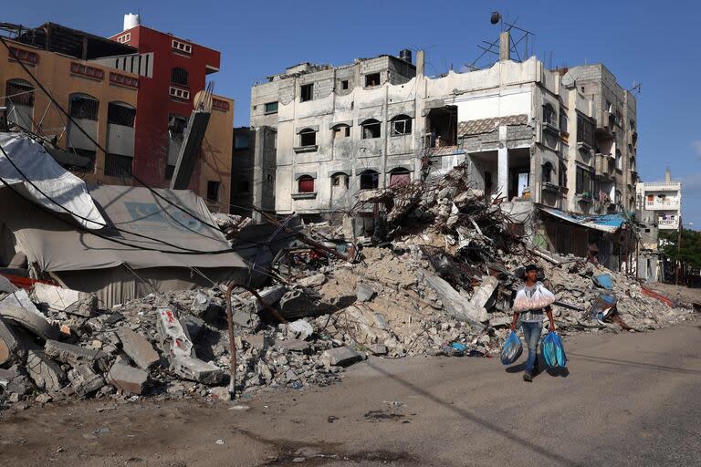 Un hombre palestino pasa junto a un edificio destruido en Rafah, en el sur de la Franja de Gaza, el 26 de mayo de 2024, en medio del conflicto entre Israel y el grupo militante Hamas