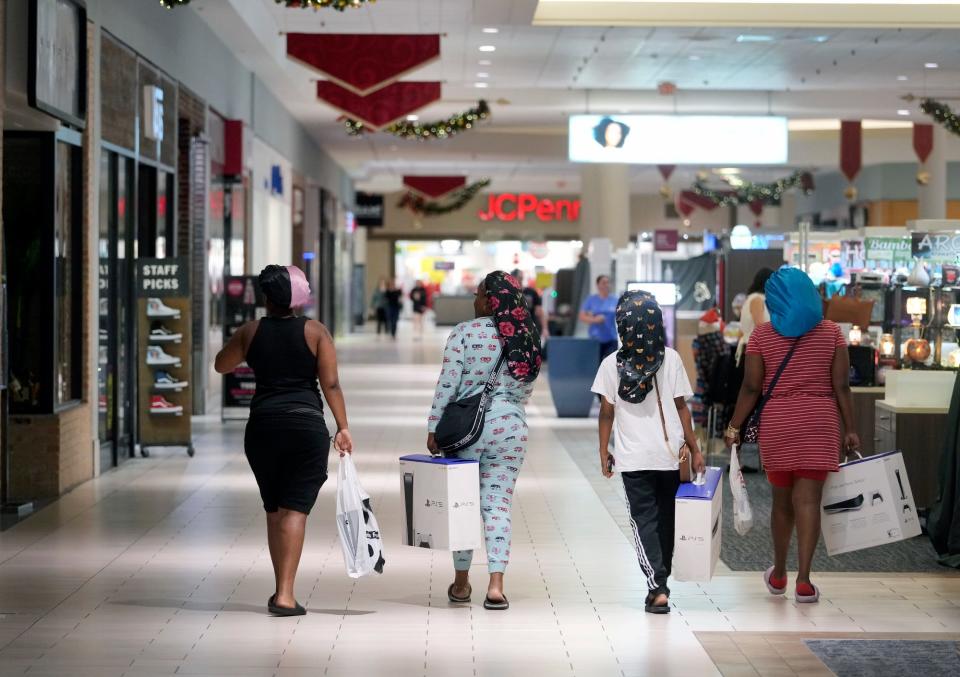 Shoppers stroll with their purchases on Black Friday at Volusia Mall in Daytona Beach. Although lines were shorter at some stores, many shoppers still embraced the traditional pre-dawn Black Friday ritual.