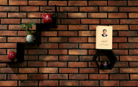 An Urdu language book about Chinese President Xi Jinping rests on a shelf with decorations at a Chinese restaurant in Islamabad, Pakistan June 9, 2017. REUTERS/Caren Firouz