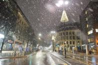 <p>Colmore Row in Birmingham city centre under a heavy shower of snow. The rain and snow is not expected to clear the mainland until around 7pm tonight. (Michael Scott/Caters News) </p>