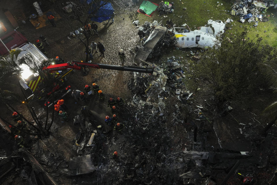 Firefighters and rescue workers work in the debris at the site where an airplane with 61 people on board crashed in Vinhedo, Sao Paulo state, Brazil, Saturday Aug. 10, 2024. (AP Photo/Andre Penner)