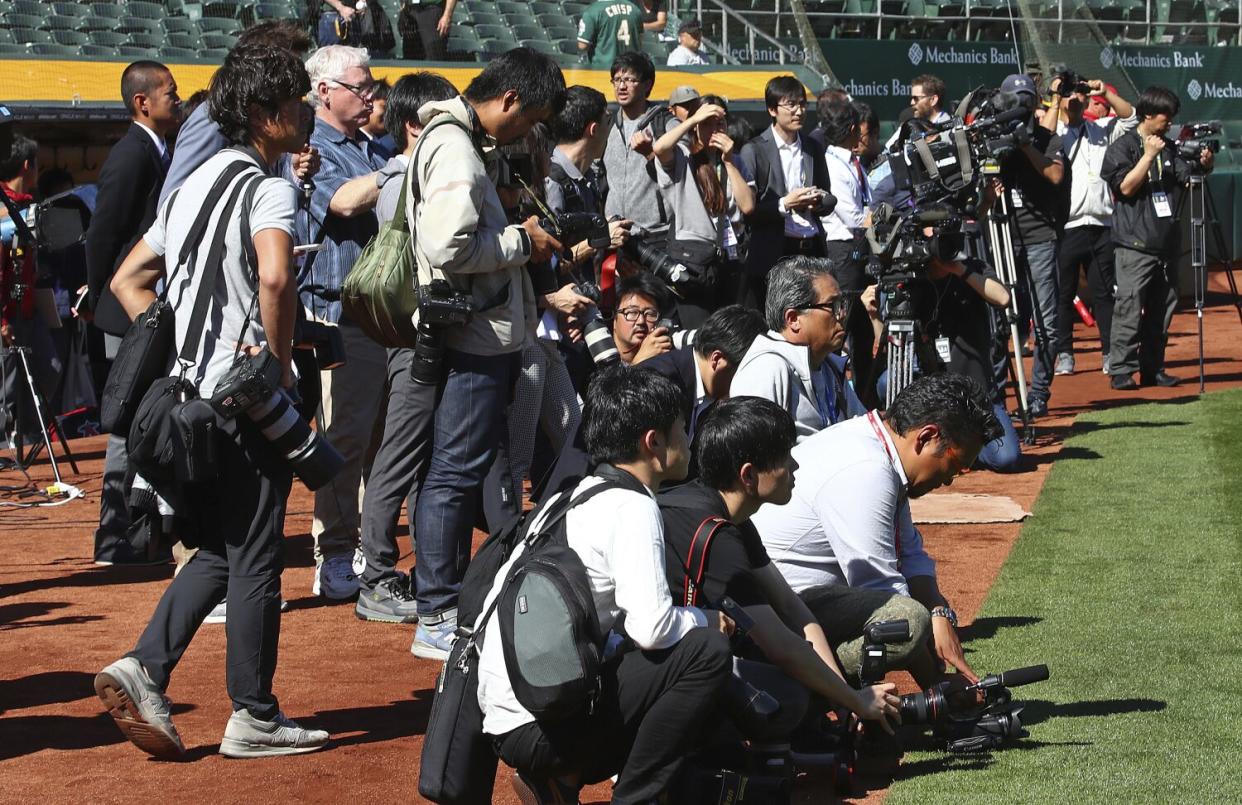 Media gather in front of the Angels dugout as they await Shohei Ohtani to return from batting practice