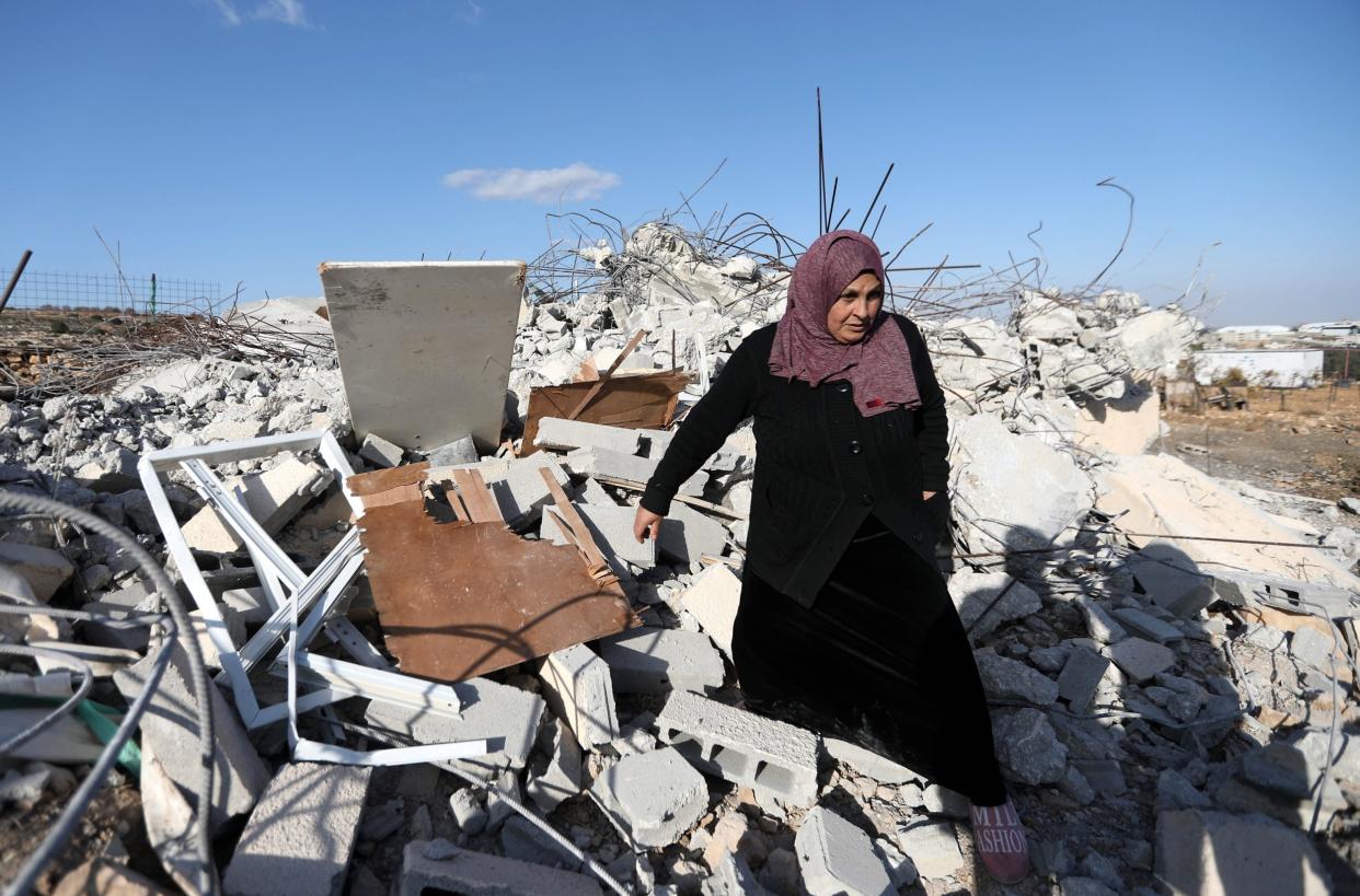 A Palestinian woman checks ruins of a house after it was demolished by Israeli troops in the West Bank village of Khader, near Bethlehem: EPA