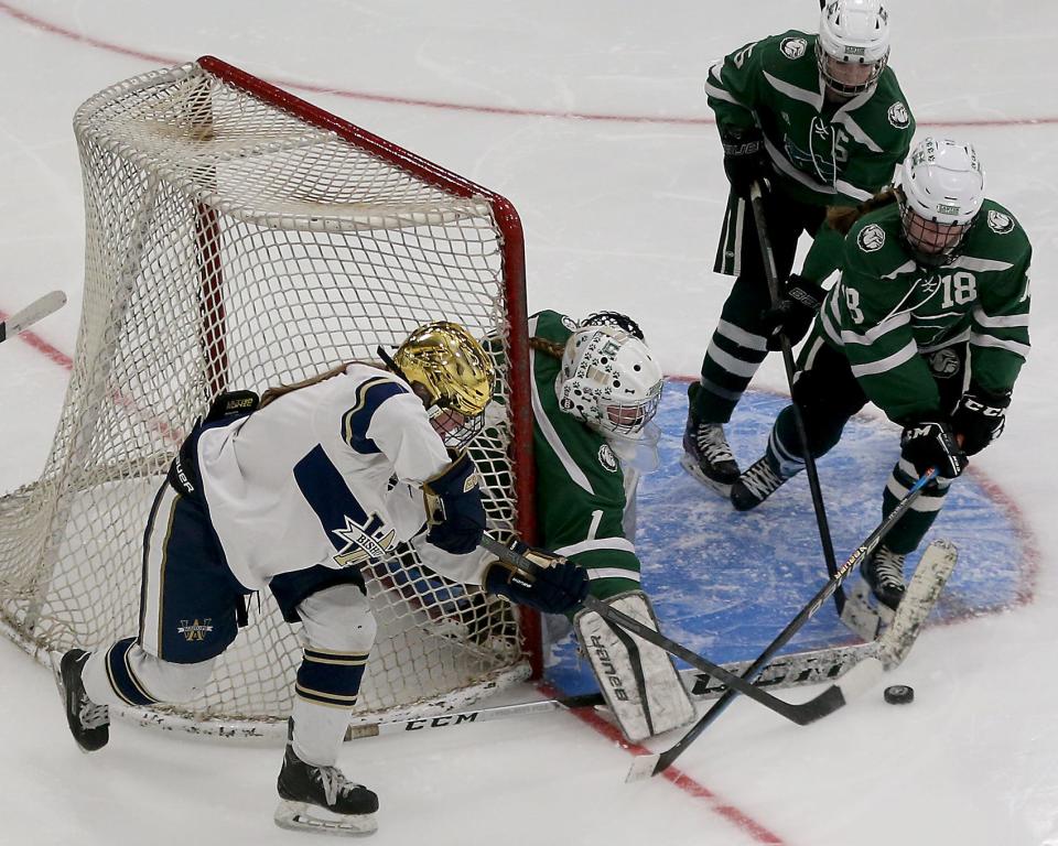 Canton goalie Carolyn Durand clears the puck off the stick of Archbishop Williams's Colleen Sansone during second period action of their game in the Division 2 state semifinal at Gallo Ice Arena in Bourne on Saturday, March 11, 2023.