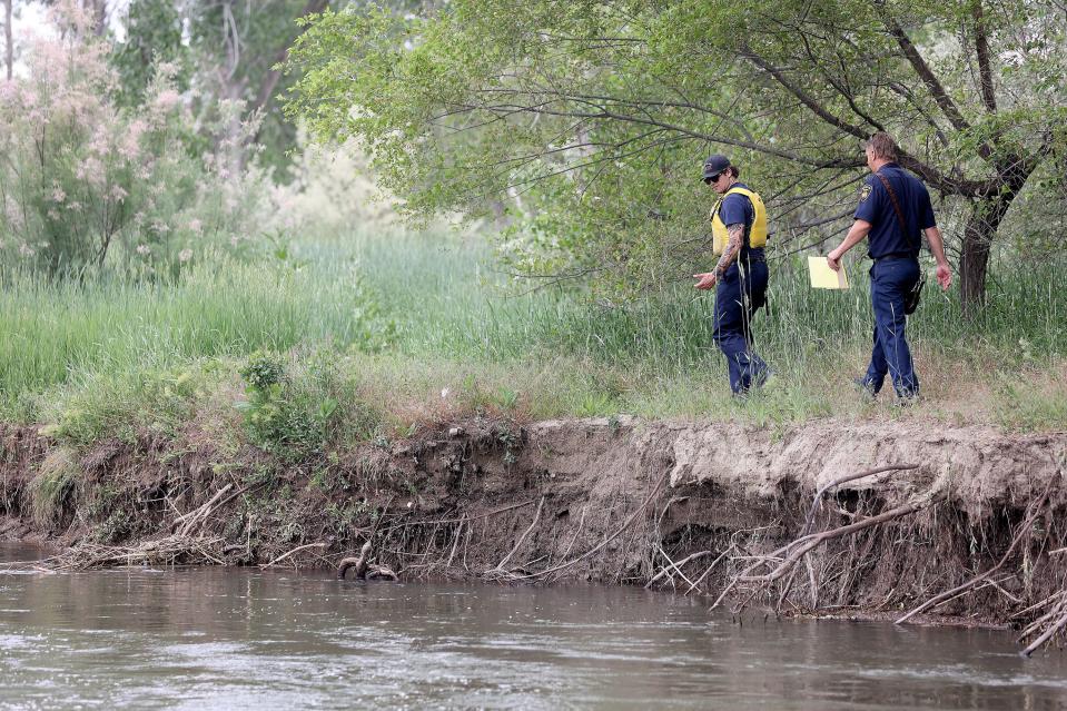 South Salt Lake firefighters look for a capsized canoe in the Jordan River in South Salt Lake on Tuesday, June 13, 2023. Seven kids and two counselors that were part of the Tracy Aviary summer youth group went into the water when their boats capsized, but all made it safely to shore without any injuries. | Kristin Murphy, Deseret News