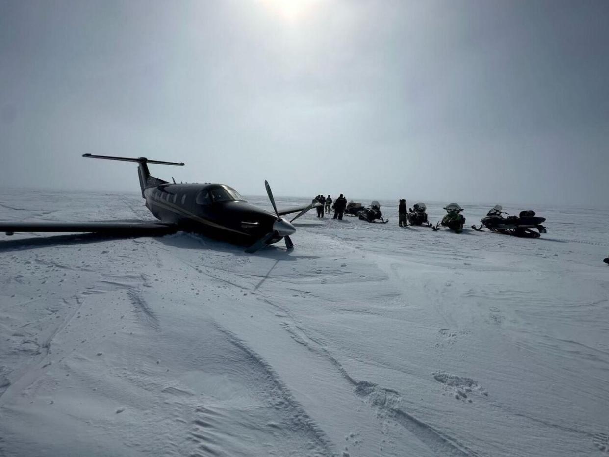 People on their snowmobiles went out to where a plane went down near Rankin Inlet, Nunavut, on Tuesday morning. The two pilots and one passenger who were on the plane are safe, according to Kudlik Aviation.  (Submitted by Harry Towtongie  - image credit)