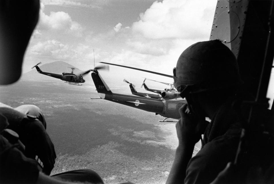 <p>A crewman in a US helicopter watches a group of escorting Bell Huey helicopters during an operation in the Vietnam War. (Photo: Terry Fincher/Daily Express/Hulton Archive/Getty Images) </p>