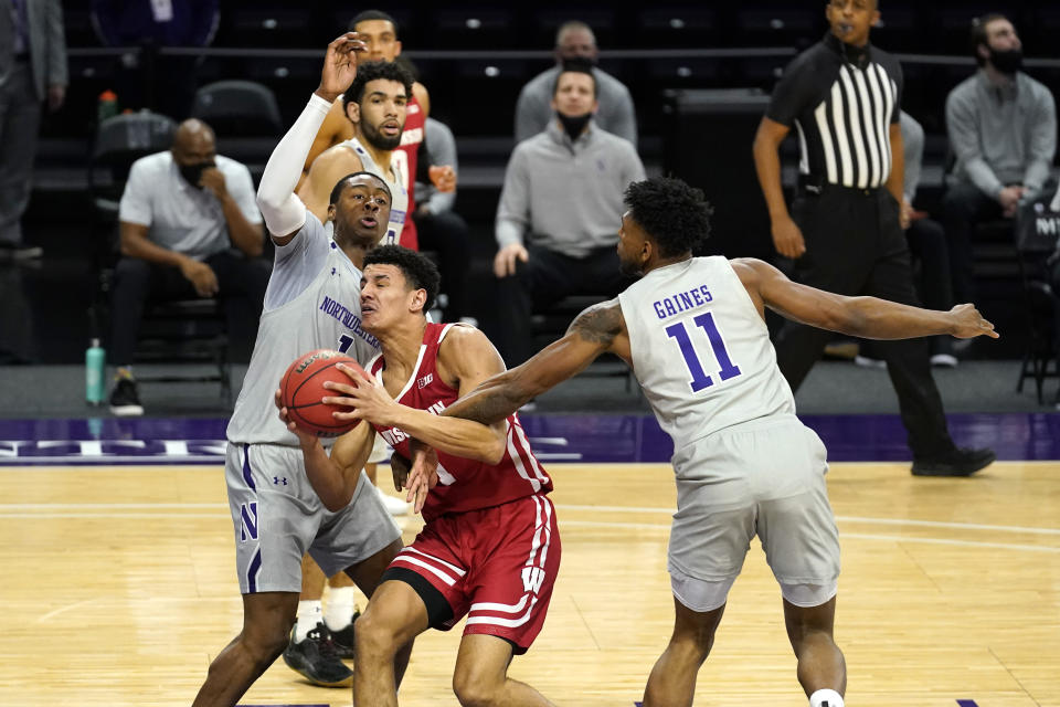 Wisconsin guard Jonathan Davis, center, drives against Northwestern guard Chase Audige, left, and guard Anthony Gaines during the first half of an NCAA college basketball game in Evanston, Ill., Saturday, Feb. 21, 2021. (AP Photo/Nam Y. Huh)