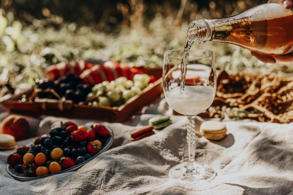 wine pouring from a bottle into glass on a picnic close up