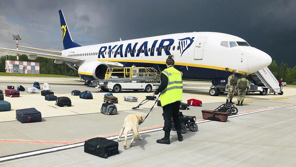 Security officers use a sniffer dog to check the luggage of passengers on the Ryanair plane carrying opposition figure                  Roman Protasevic, which was diverted to Minsk on May 23, 2021. Western leaders decried the diversion of a plane to Belarus in order to arrest an opposition journalist as an act of piracy and terrorism. / Credit: ONLINER.BY via AP