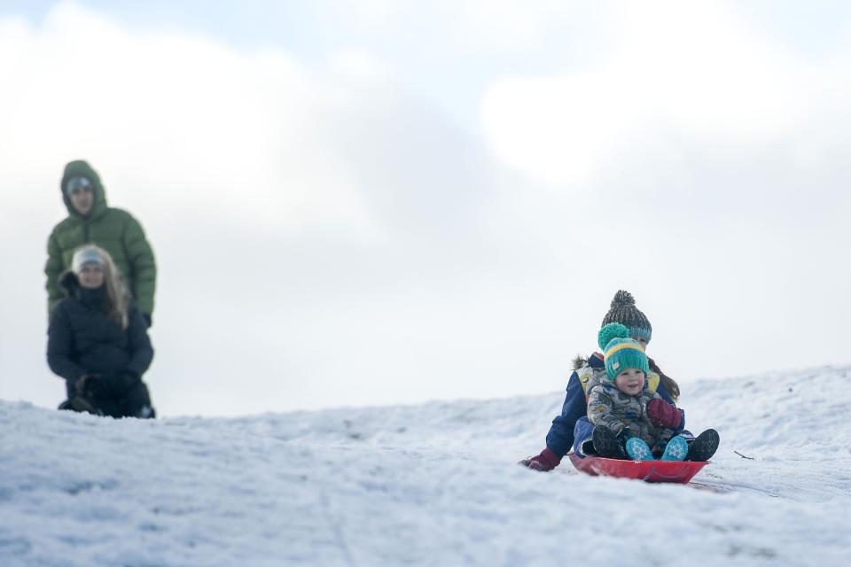 Children are seen sledging on a snow covered golf course. (Getty Images)