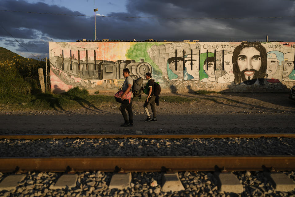 Migrants walk along rail lines hoping to board a freight train heading north, in Huehuetoca, Mexico, Sept. 19, 2023. Ferromex, Mexico's largest railroad company announced that it was suspending operations of its cargo trains due to the massive number of migrants that are illegally hitching a ride on its trains moving north towards the U.S. border. (AP Photo/Eduardo Verdugo)