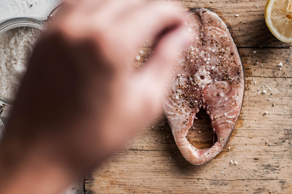 Salting a piece of fish.