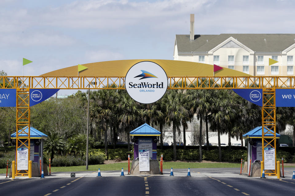 The entrance to the SeaWorld Theme park remains closed Monday, March 30, 2020, in Orlando, Fla. SeaWorld is indefinitely furloughing more than 90% of its employees and they won't get paid after March 31. (AP Photo/John Raoux)