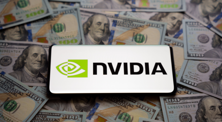 Nvidia logo seen on smartphone which is placed on pile of US dollar bills. Concept. Selective focus. Stocks to buy like Nvidia