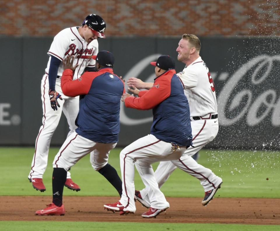 Atlanta Braves' Austin Riley, left, celebrates after hitting a walk-off RBI single to end game one