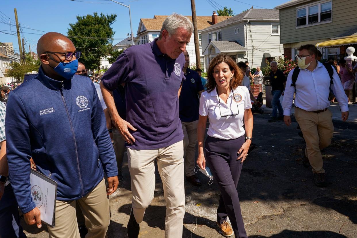 New York Gov. Hochul, right, Mayor de Blasio, center, and Queens Borough President Donovan Richards walk together after a news conference near a home where people were killed when their basement apartment was flooded in the Jamaica neighborhood of Queens, Sept. 2, 2021. 