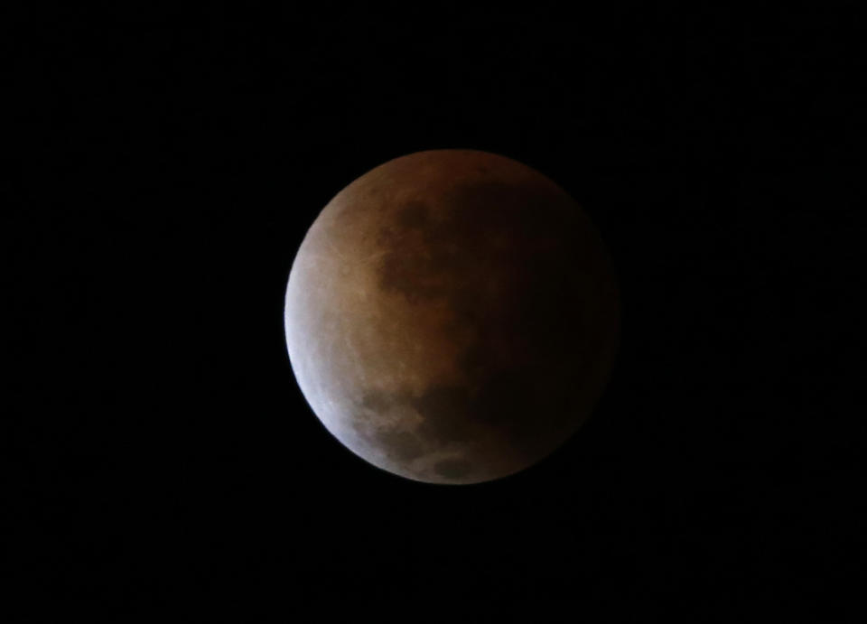The moon is seen as it begins a total lunar eclipse that will turn the moon red over Buenos Aires April 15, 2014. (REUTERS/Enrique Marcarian)