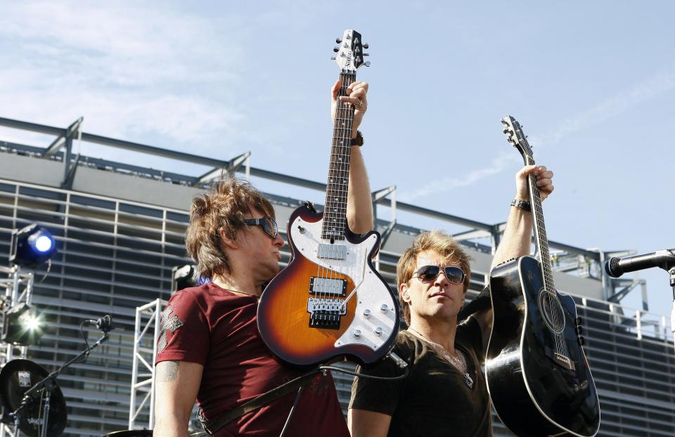 New Jersey natives Richie Sambora and Jon Bon Jovi, right, hold up their guitars as they perform Thursday, Oct. 22, 2009, during an invitation only performance by Bon Jovi for 5,000 fan club contest winners and construction workers outside the New Giants Stadium in East Rutherford, N.J. The band announced a two-year world tour that will begin May 26 with a show at New Jersey's new $1.6 billion Meadowlands football stadium. It will be the first concert inside the new venue, which is nearing completion.