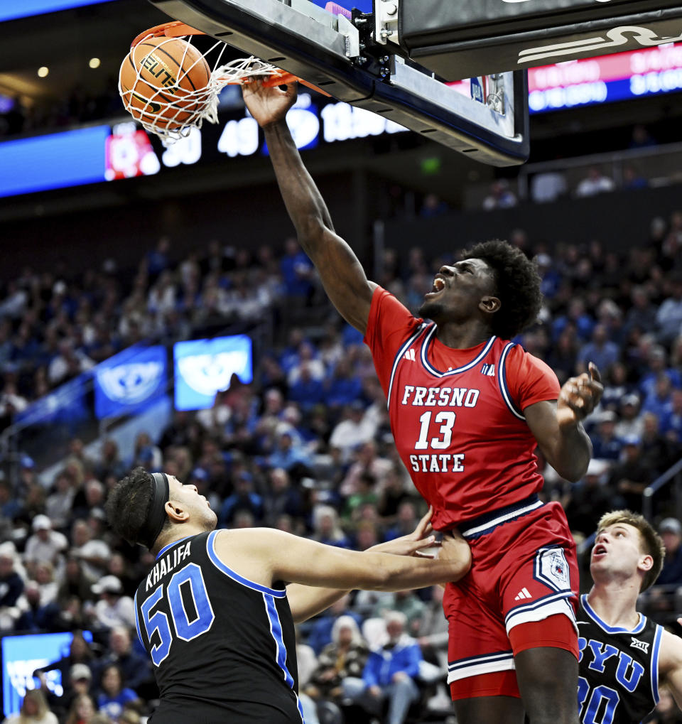 Fresno State center Enoch Boakye (13) dunks over BYU center Aly Khalifa (50) during an NCAA college basketball game in Salt Lake City, Friday, Dec. 1, 2023. (Scott G Winterton/The Deseret News via AP)