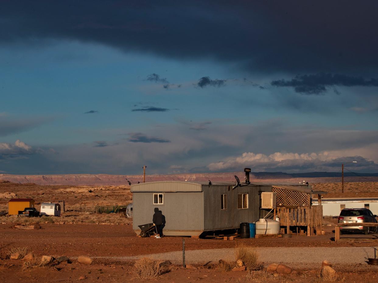 A boy carries a wheel barrel full of wood to heat his rural mobile home in freezing temperatures during the coronavirus pandemic on the Navajo reservation on March 27, 2020 in Cameron, Arizona.