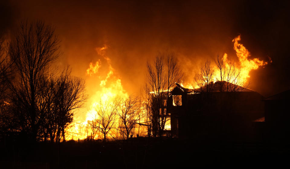 Homes burn as wildfires rip through a housing development Thursday, Dec. 30, 2021, in Superior, Colo. (AP Photo/David Zalubowski)