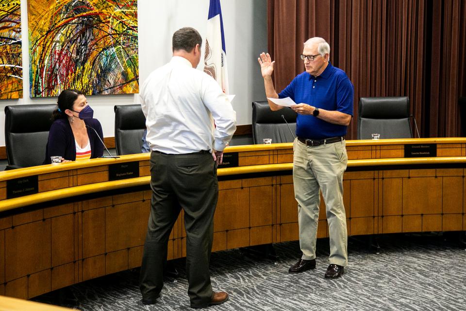 Keith Jones, right, is sworn in by Coralville city attorney Kevin D. Olson during a council meeting Tuesday as Meghann Foster, mayor of Coralville, looks on. Jones is set to fill the final 18 months of Jill Dodds' term on the City Council.