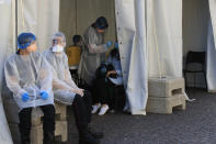 Paris fire fighters collect nasal swab samples to test for COVID-19 outside a district town-hall in Paris, Monday, Sept.21, 2020. French health authorities have started opening new testing centers in the Paris region to try to reduce queues and delays as the number of infections is steadily increasing in the country. In total, they are planning to open 20 new testing centers in the French capital and in the suburbs this week. (AP Photo/Michel Euler)