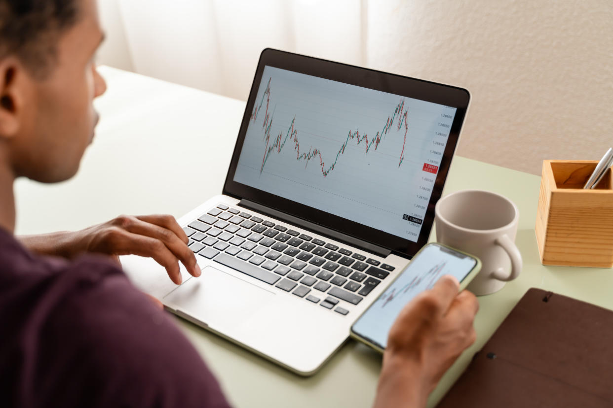 man investing and trading in stock markets with laptop