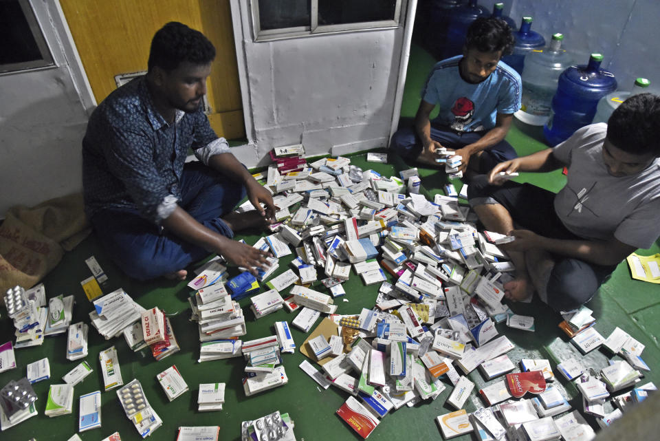 In this photo provided by Bidyanondo Foundation, health workers sort medicines in their boat hospital at Banishanta near Mongla seaport in southwestern region of Bangladesh, on Sept. 1, 2020. A Bangladeshi charity has set up a floating hospital turning a small tourist boat into a healthcare facility to provide services to thousands of people affected by this year's devastating floods that marooned millions. (Bidyanondo Foundation via AP)