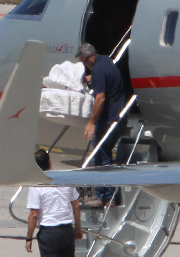 George carefully carried one of the babies off the jet. Source: Australscope