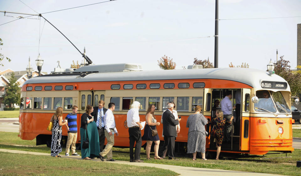 In this Sept. 28, 2013 photo, passengers board the Johnstown (Kenosha) streetcar during Kenosha Streetcar Day in Kenosha, Wis. Long after the streetcar was driven to the edge of extinction in America by the automobile _ hanging on only in a few places like New Orleans and Philadelphia _ cities are spending millions putting them back in, often along the same stretches of pavement where rail was wrenched out decades ago. The idea is that streetcars can form the heart of communities built around them, igniting economic development in urban centers that badly need it and offering a whiff of excitement to boot. (AP Photo/Michael Schmidt)