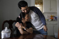 John Paul Garcia, de 20 años, abraza a su madre en su casa de Burlington, Carolina del Norte, el jueves 12 de marzo de 2020. (AP Foto/Jacquelyn Martin)