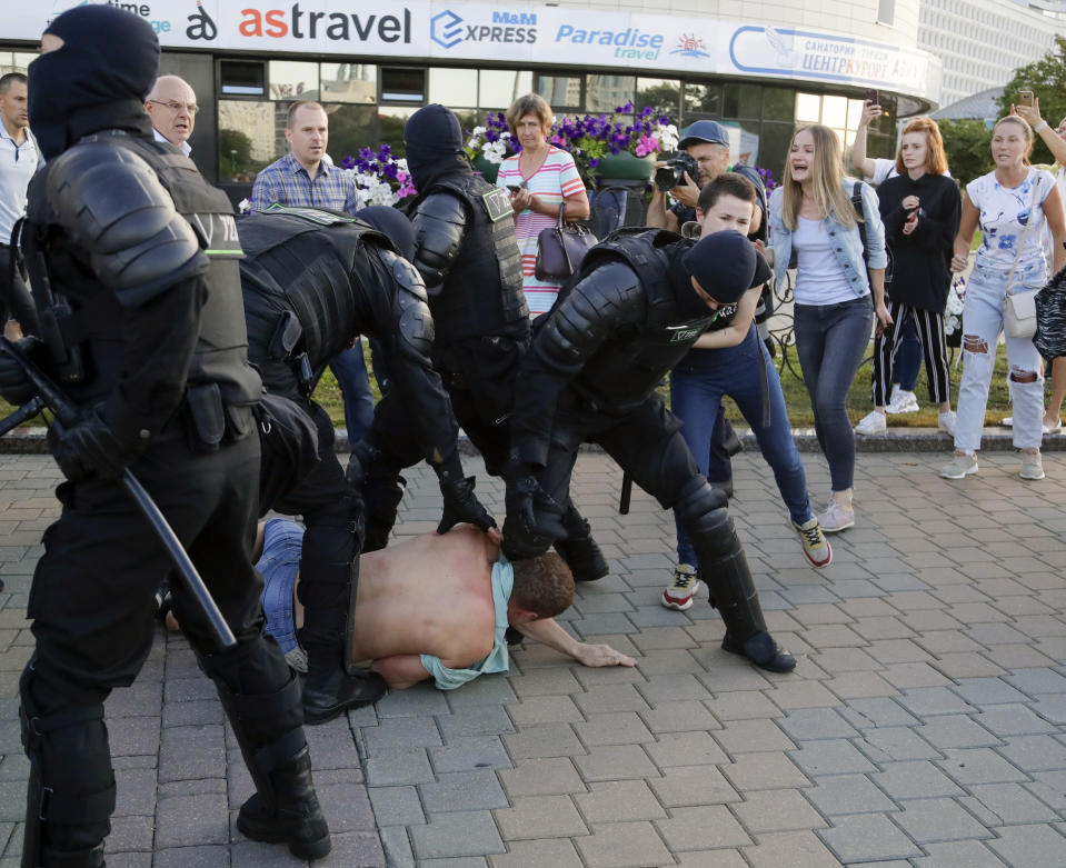 Police try to detain protesters during a rally following presidential elections in Minsk, Belarus, Monday, Aug. 10, 2020. Thousands of people have protested in Belarus for a second straight night after official results from weekend elections gave an overwhelming victory to authoritarian President Alexander Lukashenko, extending his 26-year rule. A heavy police contingent blocked central squares and avenues, moving quickly to disperse protesters and detained dozens. (AP Photo/Sergei Grits)